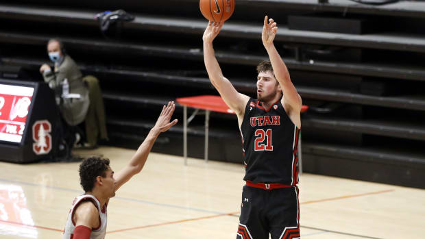 Feb 13, 2021; Stanford, California, USA; Utah Utes forward Riley Battin (21) makes a three point basket over Stanford Cardinal forward Oscar da Silva (13) during the second half at Maples Pavilion.